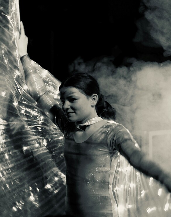 Obwohl das Foto in schwarz - weiß gehalten ist, strahlt es sie Eleganz und Würde der Tänzerin aus. Sie trägt ein Kostüm mit kleinen Lichtern (wahrscheinlich eine eingearbeitete Lichterkette)