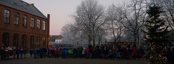Kinder singen um den Tannenbaum