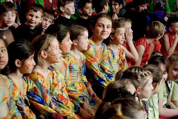 Geschmückte Tänzerinnen warten auf der Bank auf ihren Auftritt.