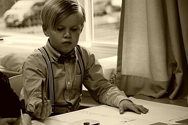 ein Junge in alter Schulkleidung sitzt im Unterricht